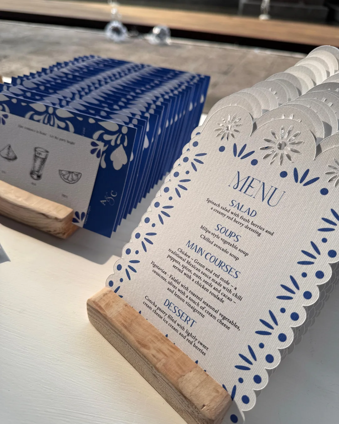 Menús azules con borde de papel picado, en bases de madera